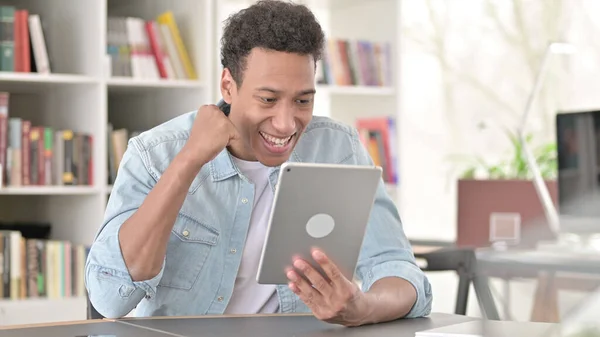 Young African American Man Celebrating Success on Tablet, Winning