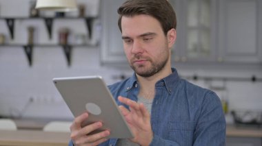 Tablet kullanan hırslı Sakallı Genç Adam 'ın Portresi