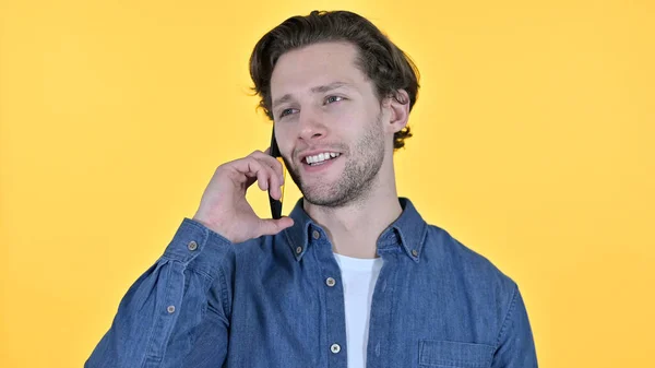Telefonförhandlingar om gul bakgrund av den unge mannen — Stockfoto