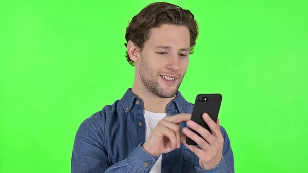 Portrait of Young Man using Smartphone on Green Chroma Key — Stock Photo, Image