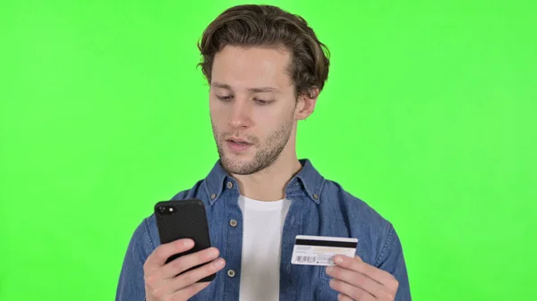 스마트폰에서 쇼핑 할 때 신용 카드를 사용하는 녹색 크로마 키 — 스톡 사진