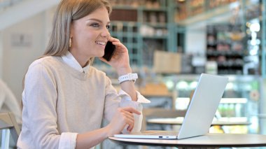 Genç Kadın Kafe 'de Akıllı Telefonla Konuşuyor