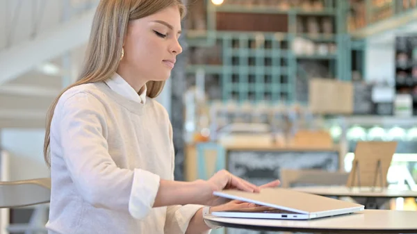 Mladá žena přichází a otevírá notebook v kavárně — Stock fotografie