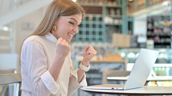 Giovane donna che celebra sul computer portatile in Cafe, Successo — Foto Stock