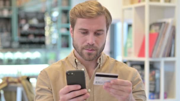 Portrét online platební úspěch mladého muže na telefonu — Stock video