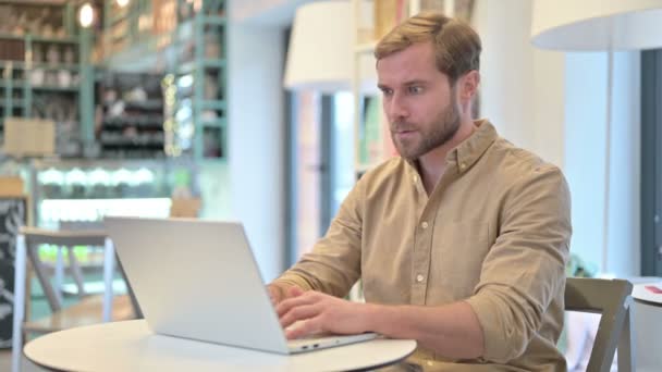 Молодий чоловік втрачає ноутбук у кафе — стокове відео