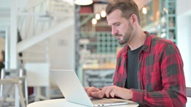 Dizüstü bilgisayarı olan genç adam Duruyor ve Gidiyor