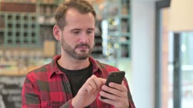 Ciddi Genç Adam 'ın Akıllı Telefon Kullanımı Portresi 