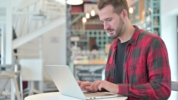 Tosse jovem homem usando laptop no café — Vídeo de Stock