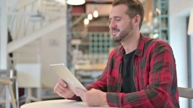 Profesyonel Genç Adam Kafe 'de Tablet' te Video Sohbeti yapıyor 