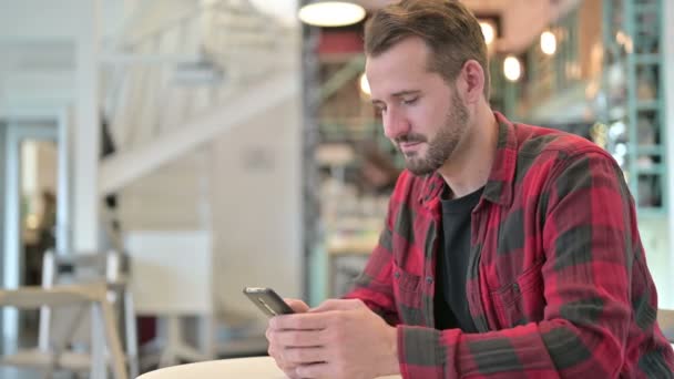 Attraktiv ung man använder smartphone i Cafe — Stockvideo