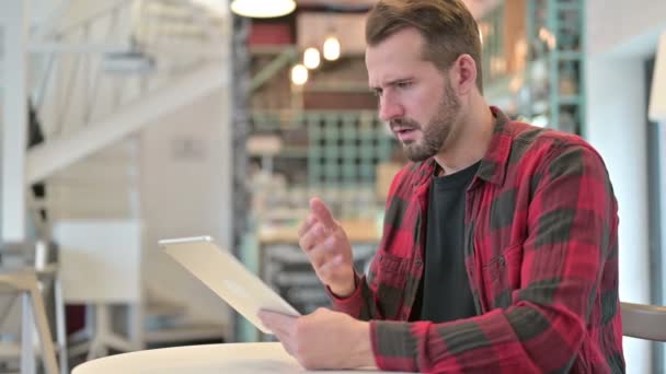 Verlust auf Tablet für enttäuschten jungen Mann im Café — Stockvideo