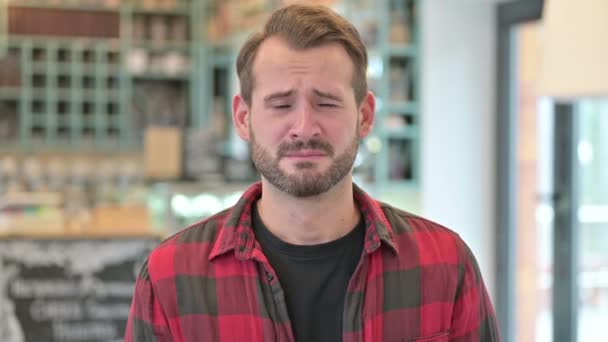 Портрет расстроенного молодого человека, плачущего перед камерой — стоковое видео