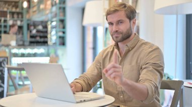 Hayır, Cafe 'de dizüstü bilgisayarlı genç adam tarafından yapılan parmak hareketi.