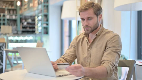 Online betalen, Winkelen op Laptop door Young Man — Stockfoto