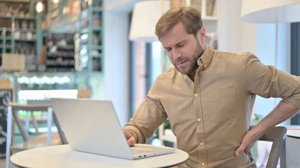 Jonge man met nekpijn met behulp van laptop in Cafe — Stockfoto