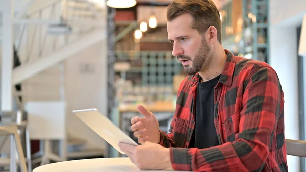 Barba giovane uomo in shock durante l'utilizzo di tablet in Cafe — Foto Stock