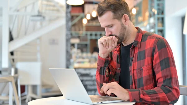 Toux barbe jeune homme en utilisant ordinateur portable dans café — Photo