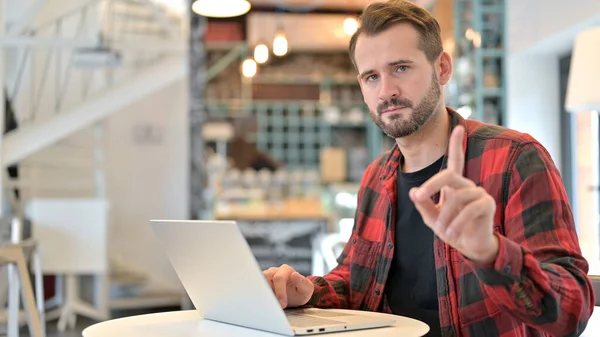 Aucun signe de doigt par barbe jeune homme avec ordinateur portable dans Cafe — Photo