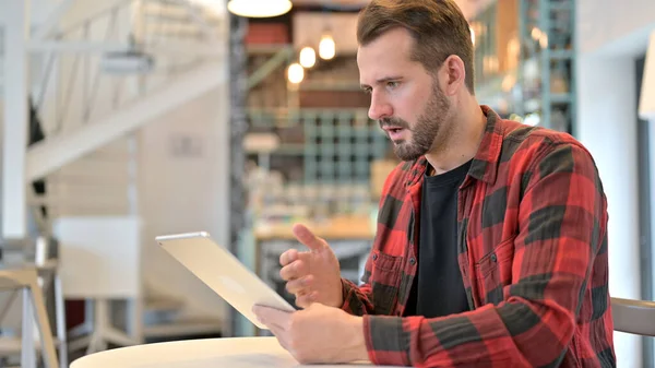 Baard jonge man in shock tijdens het gebruik van tablet in Cafe — Stockfoto