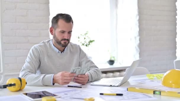 Трудолюбивый молодой архитектор считает доллары в офисе — стоковое видео