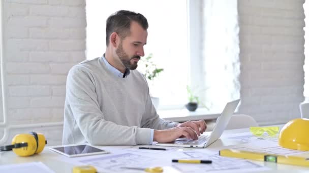 Arquitecto joven positivo con portátil haciendo pulgares hacia arriba en la oficina — Vídeos de Stock