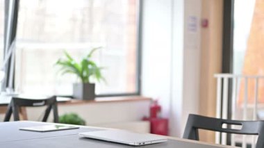Profesyonel Genç Adam geri geliyor ve dizüstü bilgisayar açıyor