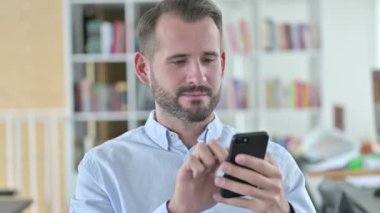Akıllı telefon kullanan Çekici Genç Adam Portresi