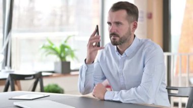 Ciddi Genç Adam Ofiste Akıllı Telefonla Konuşuyor