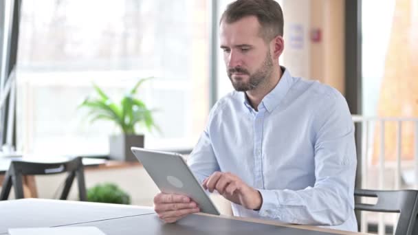 Uso de la tableta digital por el atractivo joven en la oficina — Vídeos de Stock