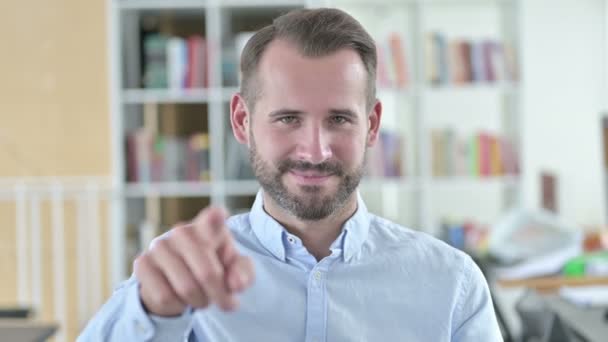 Porträt eines attraktiven jungen Mannes, der mit dem Finger zeigt — Stockvideo