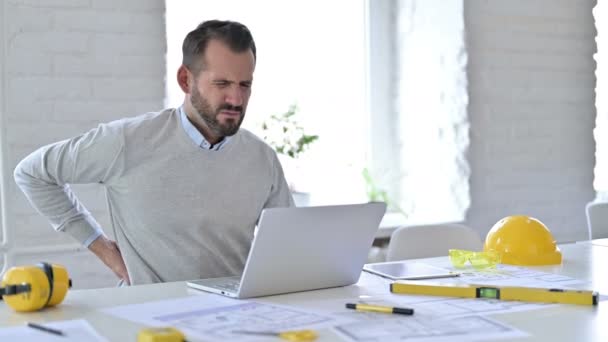 Giovane architetto con mal di schiena utilizzando il computer portatile in ufficio — Video Stock