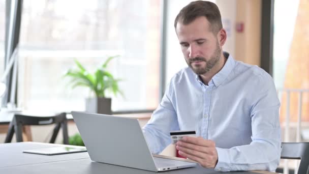 Sukces płatności online przez młodego człowieka na laptopie w biurze — Wideo stockowe
