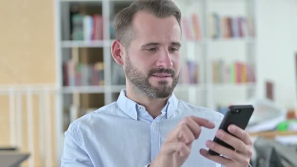 Retrato del joven celebrando el éxito en el teléfono inteligente — Vídeos de Stock