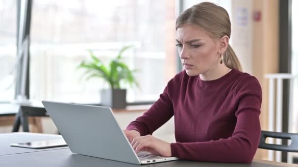 Mujer joven con dolor de cabeza utilizando el ordenador portátil en la oficina — Vídeos de Stock