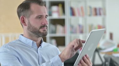 Dijital Tablet kullanan Odaklanmış Genç Adam Portresi