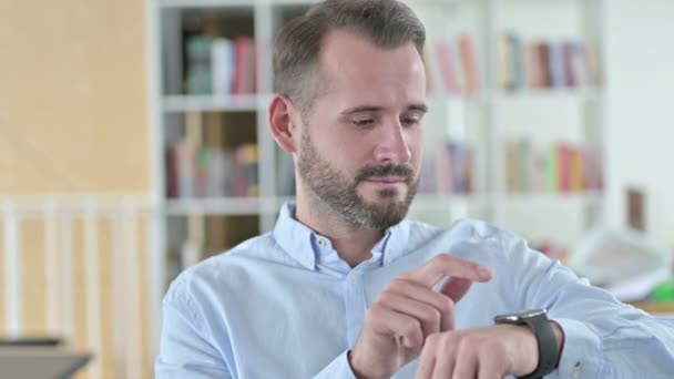 Retrato de un joven hablando en un reloj inteligente — Vídeos de Stock