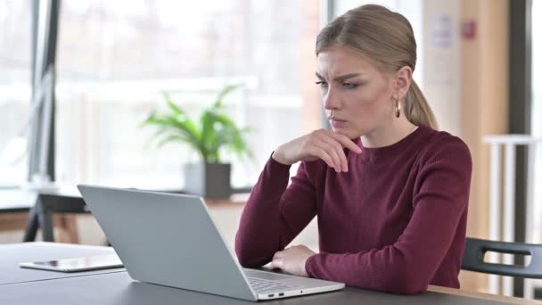 Pensive νεαρή γυναίκα χρησιμοποιώντας Laptop στο γραφείο — Αρχείο Βίντεο