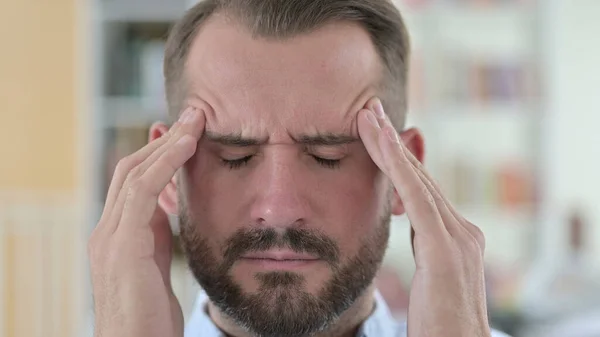 Close-up van gestresste jongeman met hoofdpijn — Stockfoto