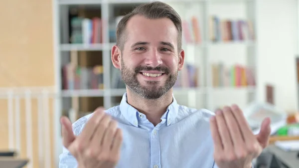 Portret van een jonge man wijzend met vinger en uitnodigend — Stockfoto