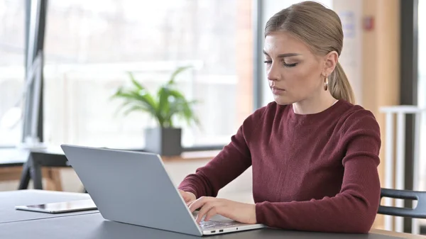 Jovem mulher profissional usando laptop no escritório — Fotografia de Stock