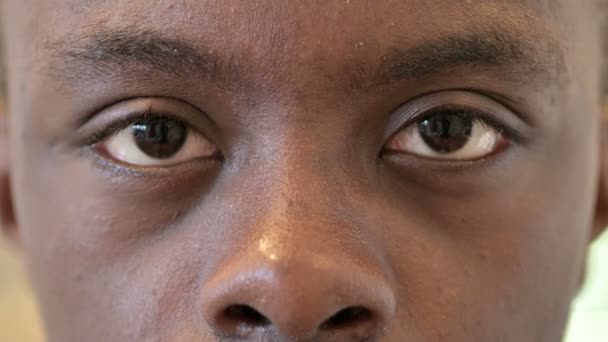 Nahaufnahme der blinkenden Augen eines jungen Afrikaners — Stockvideo
