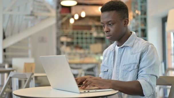 Ung afrikansk man lämnar arbetet och går bort i Café — Stockvideo