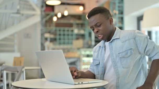 Tired Young African Man having Back Pain in Cafe — Stock Video