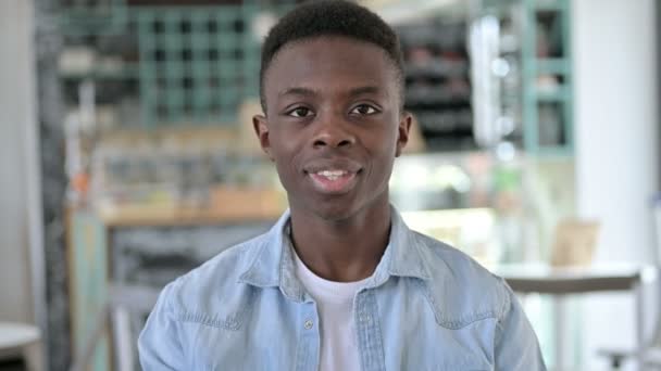 Porträt eines hübschen jungen Afrikaners, der aufzeigt und einlädt — Stockvideo