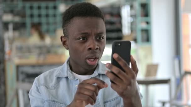 Retrato de Jovem Africano reagindo ao fracasso em Smartphone — Vídeo de Stock