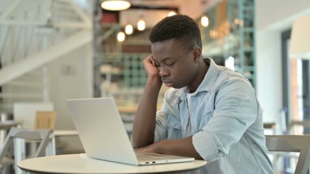 Slaperige jonge Afrikaanse man met laptop nemen van slaap in Cafe — Stockvideo