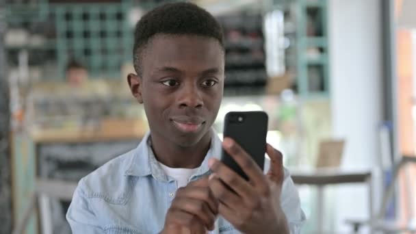 Retrato de joven africano alegre usando Smartphone — Vídeo de stock