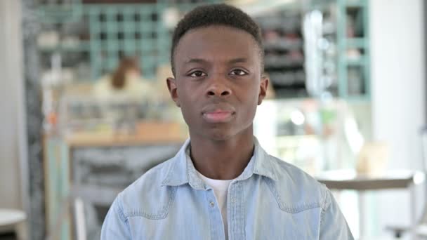Портрет грустного молодого африканца, смотрящего в камеру, расстроенного — стоковое видео
