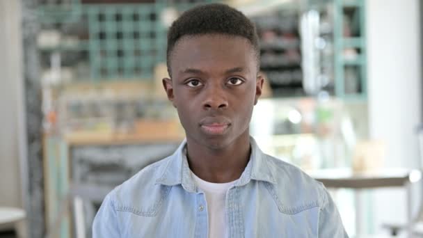 Porträtt av besviken ung afrikansk man gör tummar ner — Stockvideo